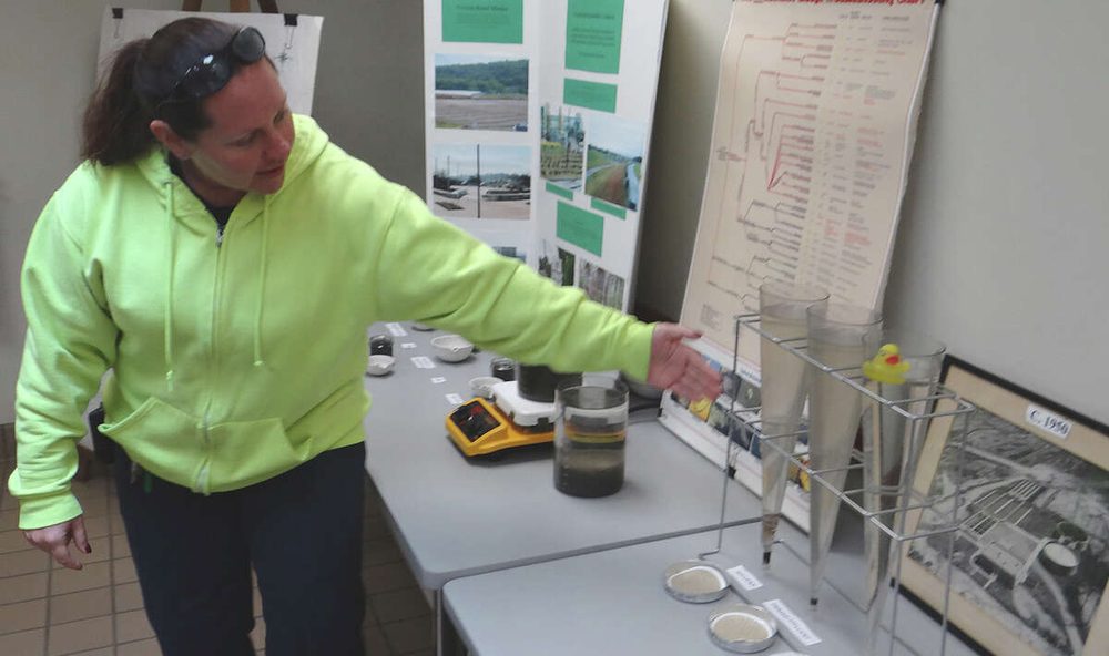 Danielle Morrison demonstrating settleometer tests and lab equipment at a training table